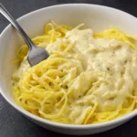 Spaghetti Squash Alfredo in a white bowl with creamy sauce