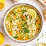 easy lemon chicken soup in a bowl with lemon slices and herbs