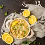 instant pot greek lemon chicken soup in a rustic bowl with lemon and parsley