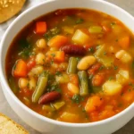 Olive Garden Vegetable Soup in a rustic bowl with fresh vegetables